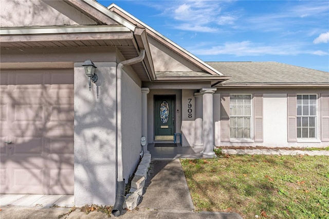 property entrance featuring a garage and a yard