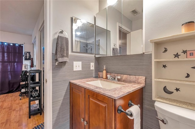 bathroom featuring hardwood / wood-style floors, vanity, toilet, and backsplash