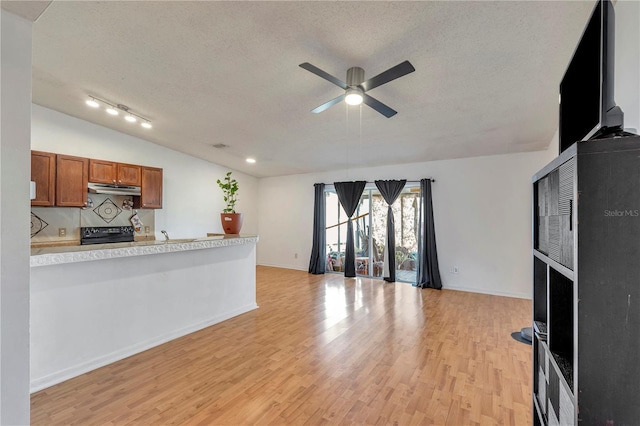 kitchen featuring ceiling fan, stove, light hardwood / wood-style floors, and a textured ceiling