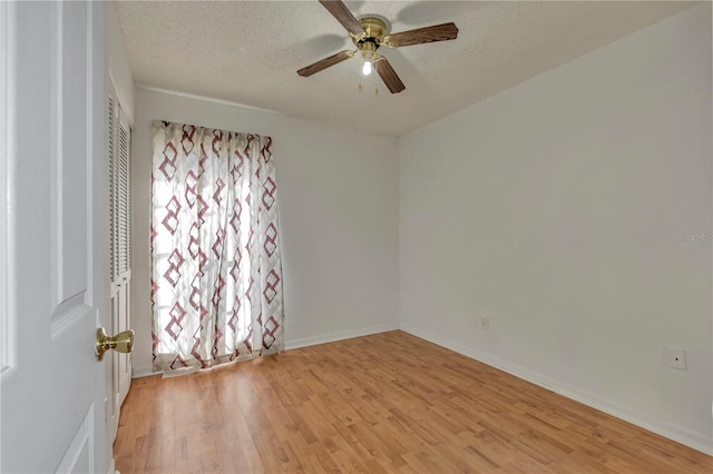 empty room featuring a textured ceiling, light hardwood / wood-style floors, and ceiling fan