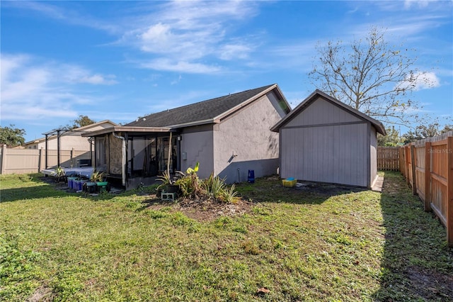 back of property with a lawn and a sunroom