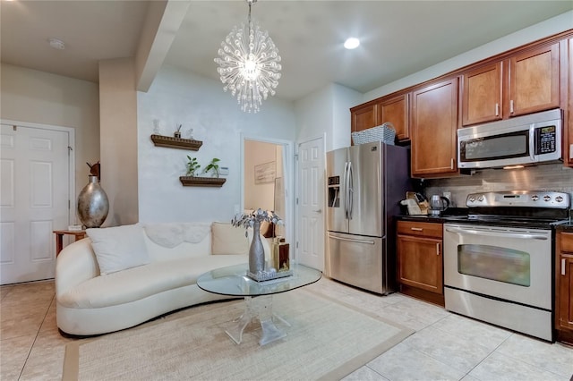 kitchen with backsplash, hanging light fixtures, light tile patterned flooring, stainless steel appliances, and a chandelier