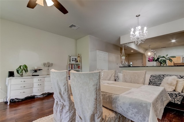 dining room with dark wood-type flooring and ceiling fan with notable chandelier