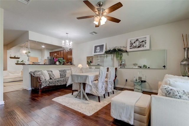 dining room featuring ceiling fan with notable chandelier and dark hardwood / wood-style flooring