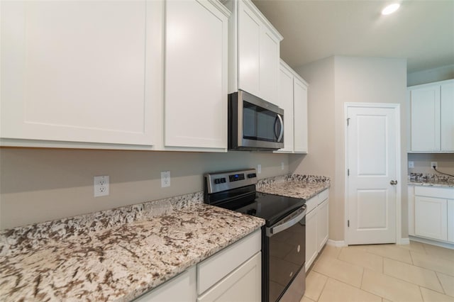 kitchen featuring light stone countertops, white cabinetry, and appliances with stainless steel finishes