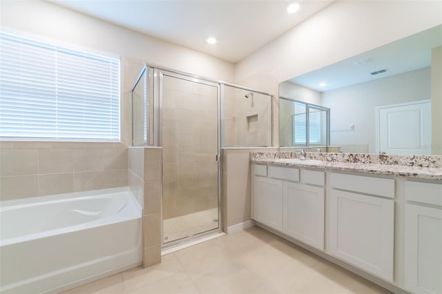 bathroom featuring plus walk in shower, tile patterned flooring, and vanity