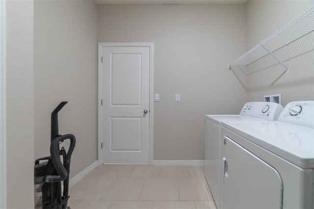 washroom with washing machine and clothes dryer and light tile patterned flooring