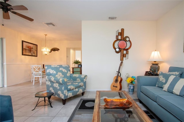 living room featuring light tile patterned floors and ceiling fan with notable chandelier