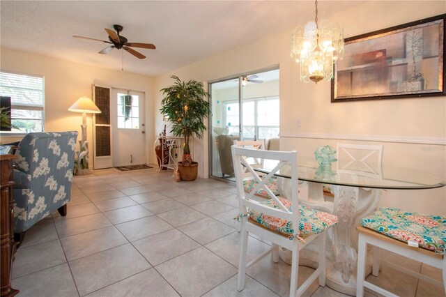 dining room with ceiling fan with notable chandelier and light tile patterned flooring