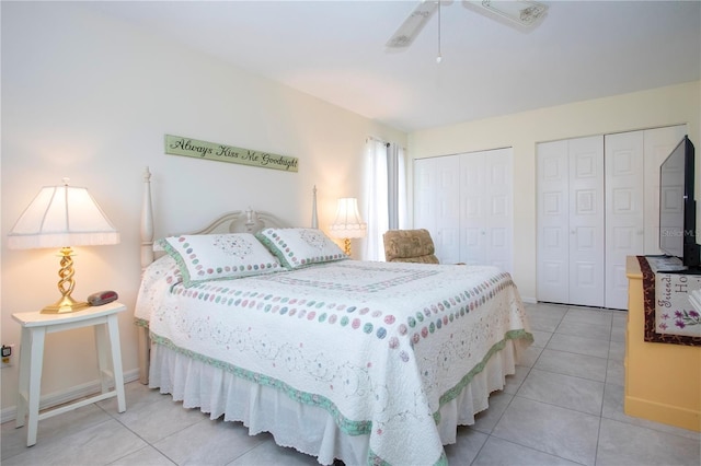 bedroom with ceiling fan, light tile patterned floors, and multiple closets