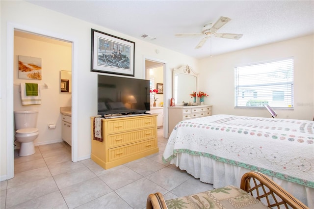 tiled bedroom with ceiling fan and ensuite bath