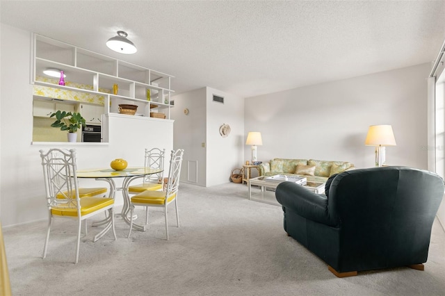 living room featuring light carpet and a textured ceiling