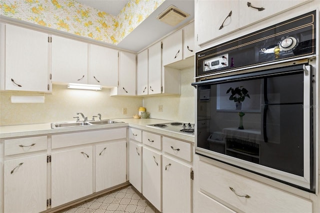 kitchen with white cabinetry, sink, oven, and white gas cooktop