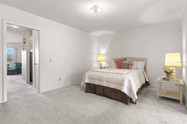 bedroom with a textured ceiling and light carpet