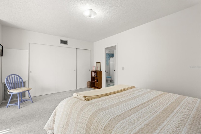 bedroom featuring light colored carpet, a textured ceiling, and a closet