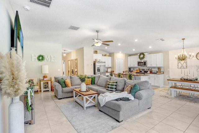 living room with light tile patterned floors, ceiling fan with notable chandelier, and vaulted ceiling