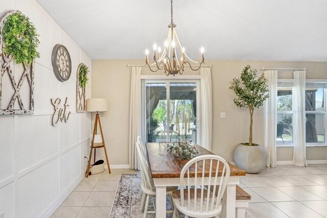 tiled dining room featuring an inviting chandelier