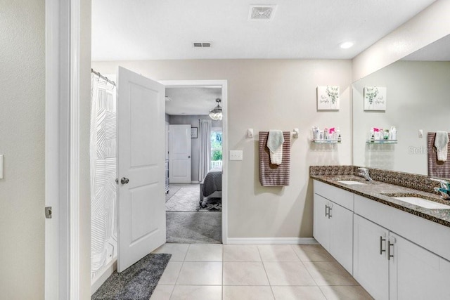 bathroom with tile patterned flooring, vanity, and ceiling fan