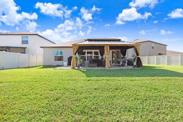 rear view of property with a gazebo, a yard, and a patio