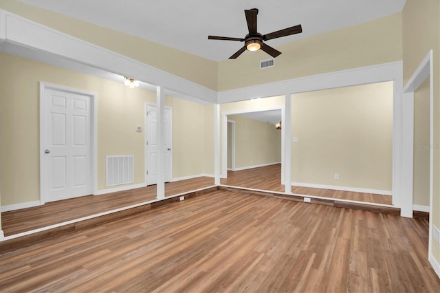 empty room with ceiling fan and hardwood / wood-style flooring