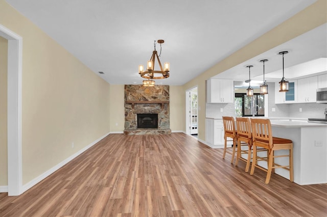 unfurnished living room featuring hardwood / wood-style flooring, a fireplace, and a chandelier