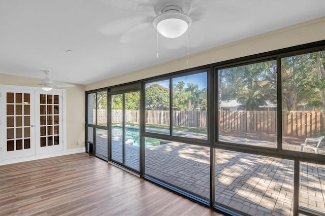 unfurnished sunroom featuring french doors and ceiling fan