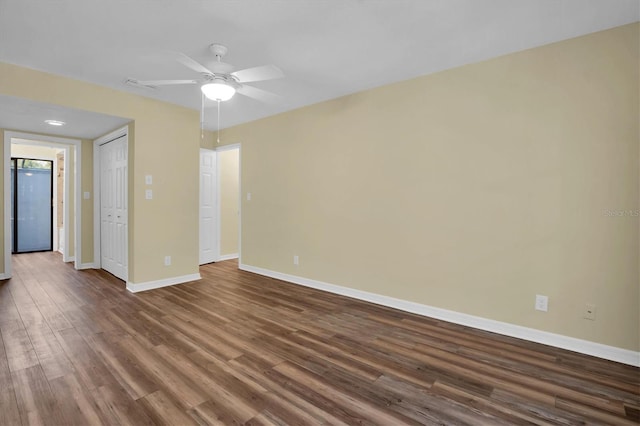 spare room with dark hardwood / wood-style flooring and ceiling fan