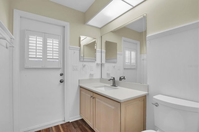 bathroom with hardwood / wood-style floors, vanity, and toilet