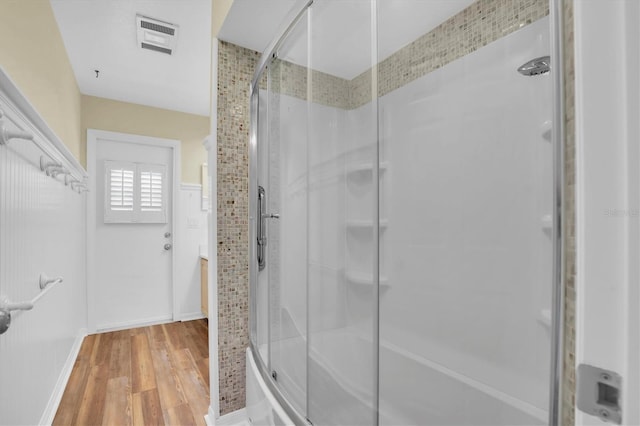 bathroom featuring vanity, bath / shower combo with glass door, and hardwood / wood-style flooring