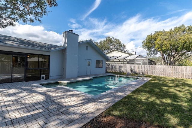 view of pool with a patio area and a yard