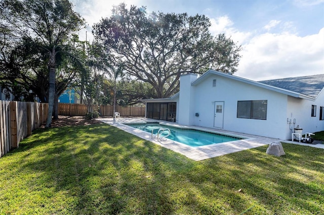 view of swimming pool featuring a lawn and a sunroom