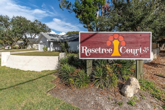 community sign with a lawn and a garage