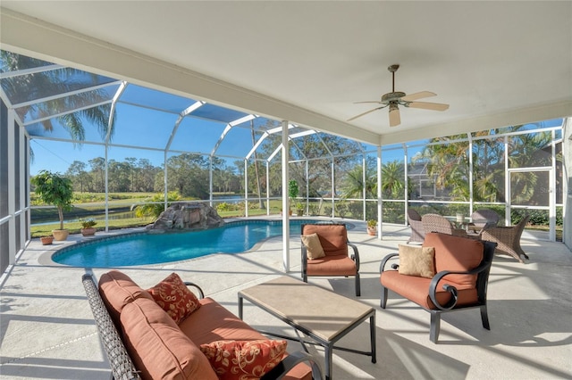 view of pool featuring glass enclosure, an outdoor hangout area, pool water feature, ceiling fan, and a patio