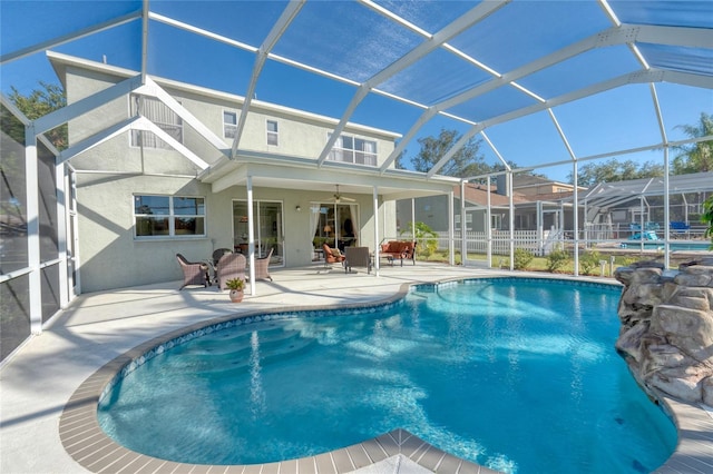 view of pool with ceiling fan, a patio, and glass enclosure