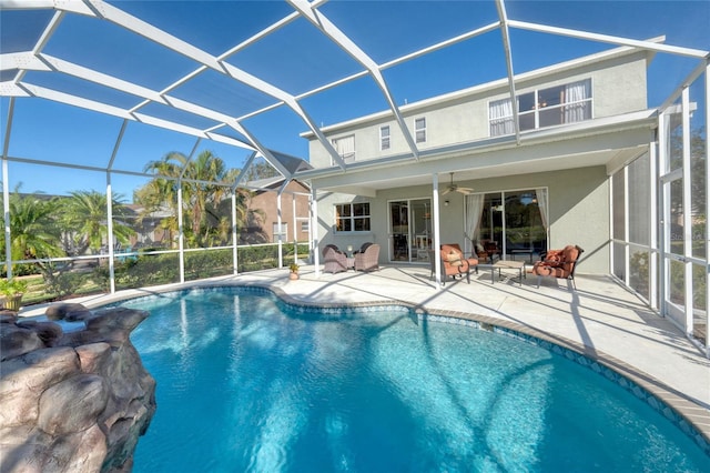 view of pool with ceiling fan, a patio area, and glass enclosure