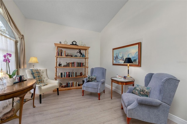 living area with light hardwood / wood-style flooring and lofted ceiling