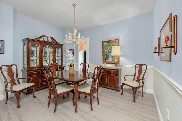 dining area with a notable chandelier and light hardwood / wood-style flooring