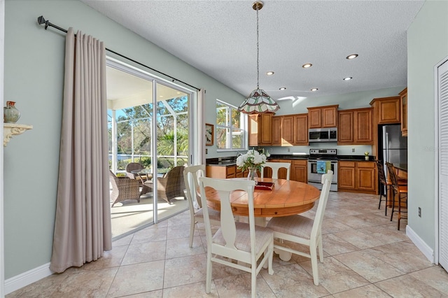 dining area featuring light tile patterned floors and a textured ceiling