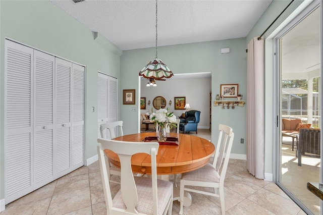 dining space with light tile patterned flooring and a textured ceiling