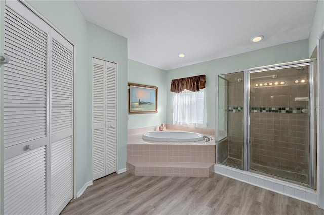 bathroom with hardwood / wood-style flooring and independent shower and bath