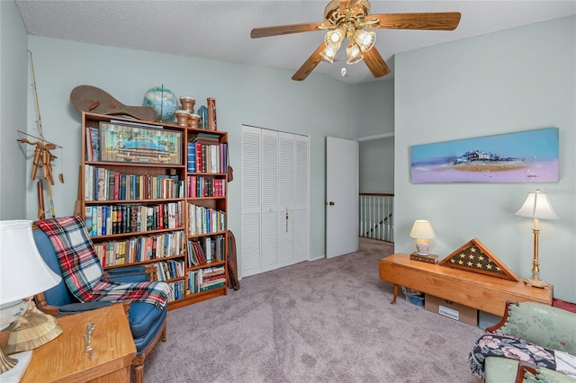 sitting room featuring light carpet, ceiling fan, and a textured ceiling