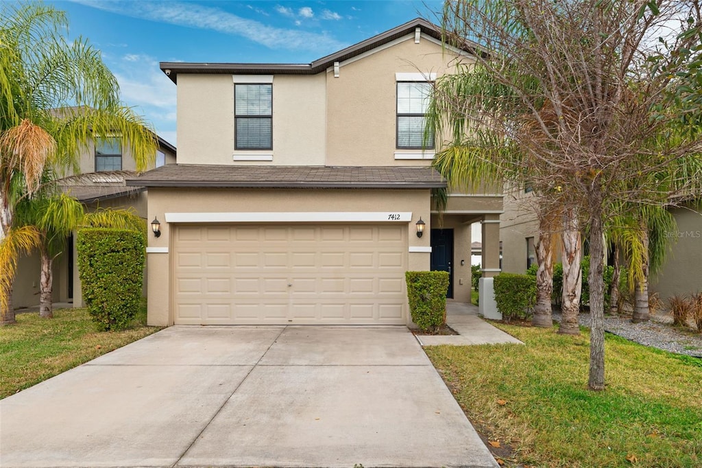 view of front facade with a garage and a front lawn