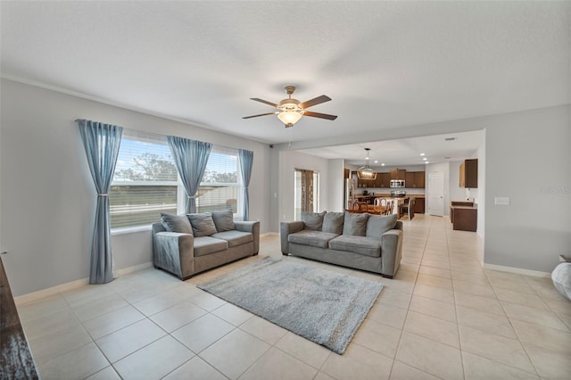 living room featuring light tile patterned floors, a textured ceiling, and ceiling fan