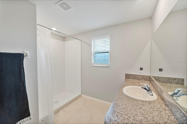 bathroom featuring tile patterned flooring, a shower with curtain, and vanity