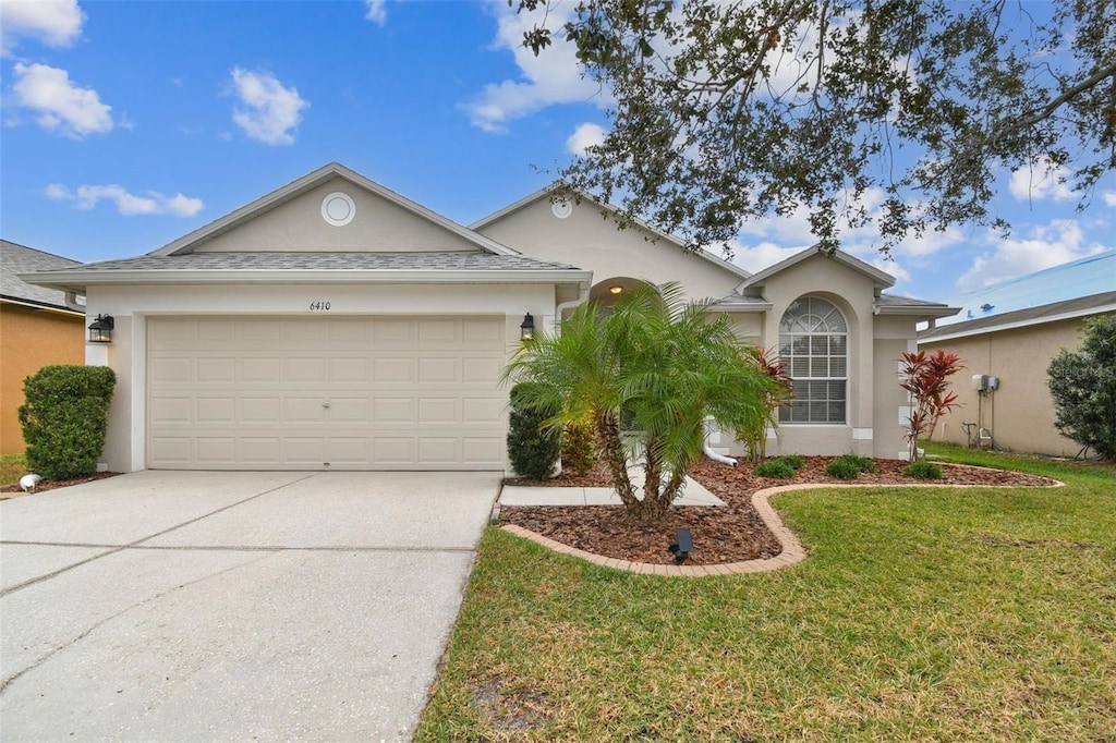 ranch-style home with a garage and a front yard