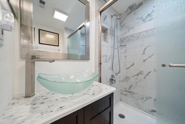 bathroom with vanity and tiled shower