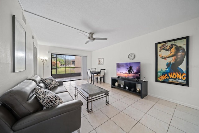 living room featuring ceiling fan, light tile patterned flooring, and a textured ceiling