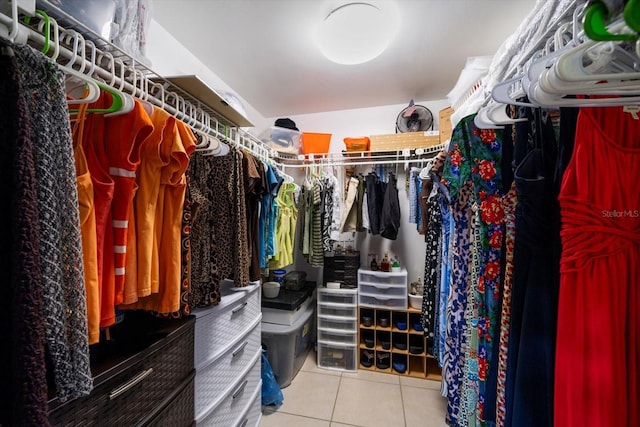 walk in closet with light tile patterned floors