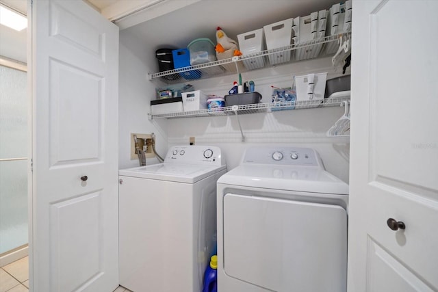 laundry area featuring washer and dryer and light tile patterned flooring