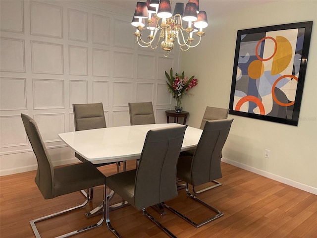 dining area featuring light hardwood / wood-style floors and a notable chandelier